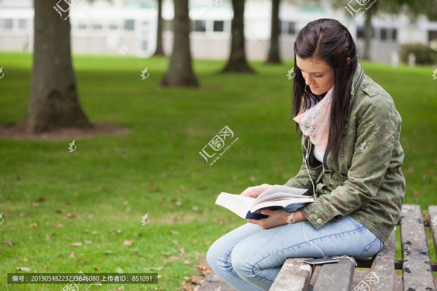 坐在长凳上看书的学生