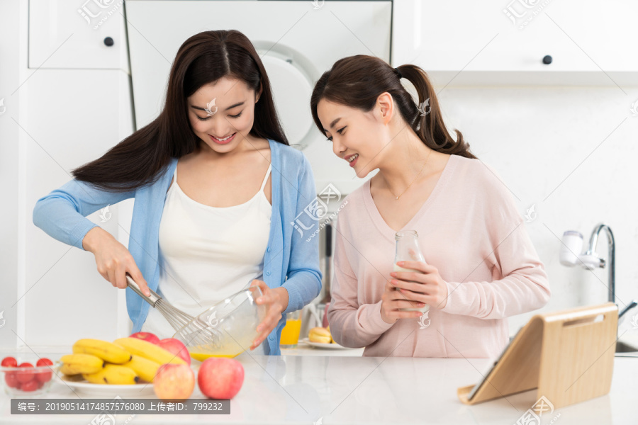 年轻女子在厨房边做饭边和朋友聊天