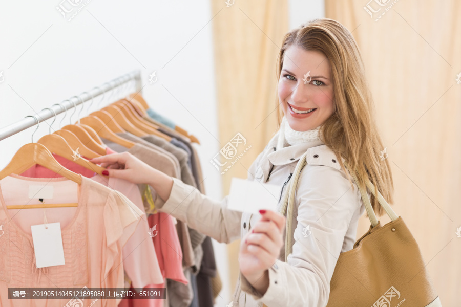 漂亮的金发女郎在商店里看衣服