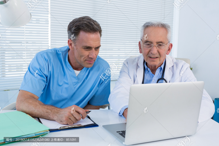 外科医生在诊所讨论笔记本电脑