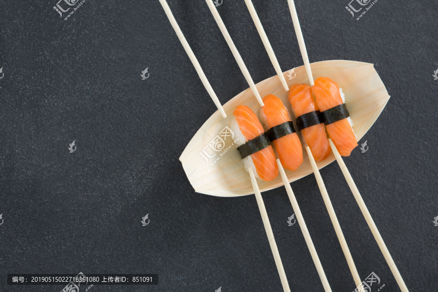 用筷子在船形盘子上做寿司特写