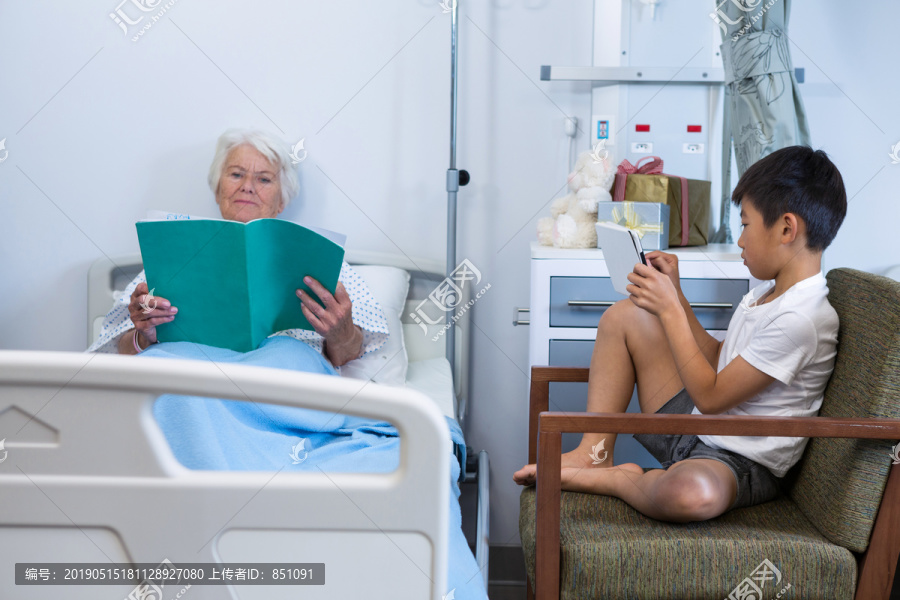老年人和男孩在医院看书