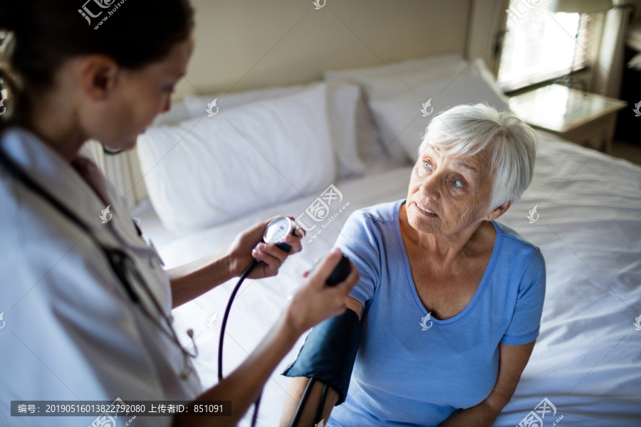 女医生在家检查老年妇女的血压