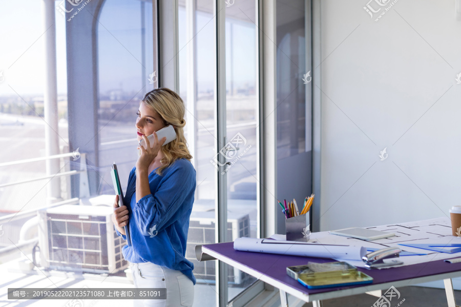 女建筑师在办公室里讲手机