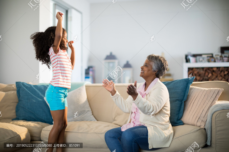 奶奶在家里客厅跳舞时为孙女鼓掌