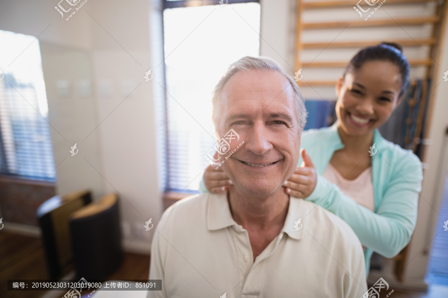 微笑的老年男性患者和女性治疗师