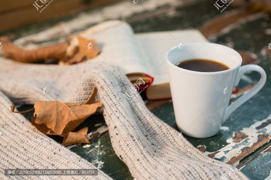 用开卷的书和咖啡杯来特写毛衣
