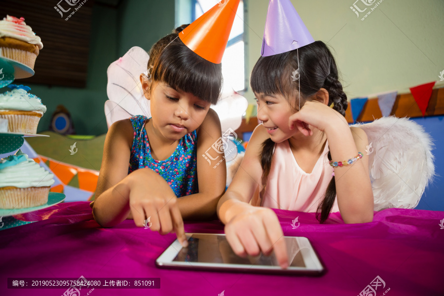 在聚会上使用平板电脑的小女孩