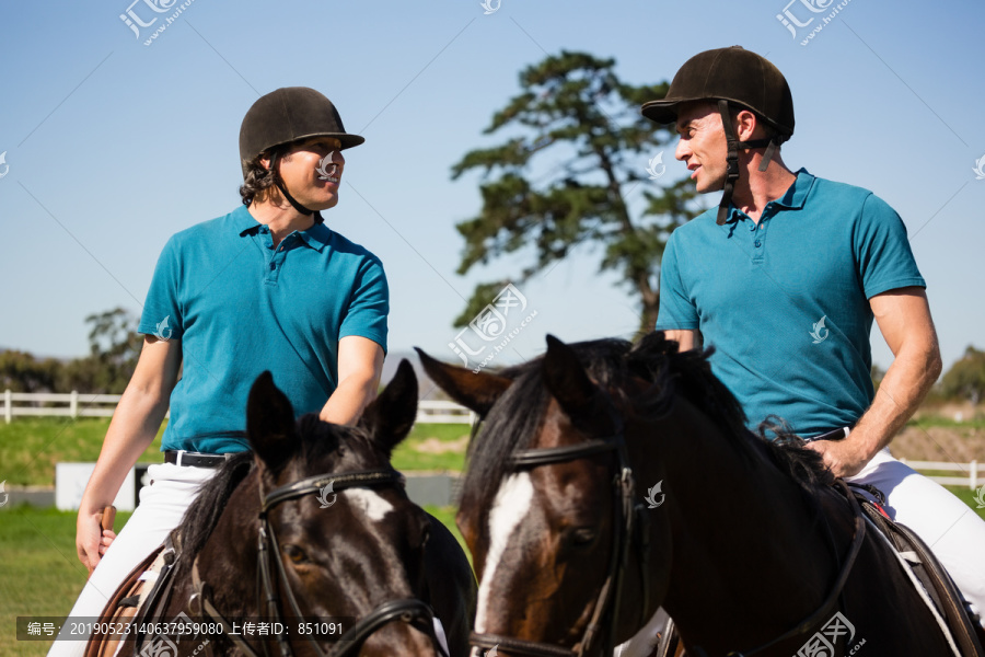 两个在牧场骑马的男骑师