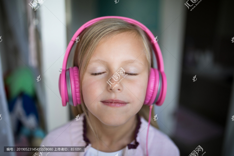 在家里用耳机听音乐的女孩