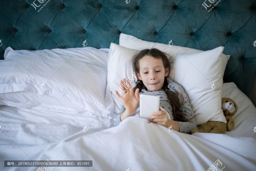 在卧室的床上用手机的女孩
