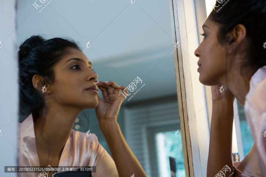 在镜子上化妆的女人