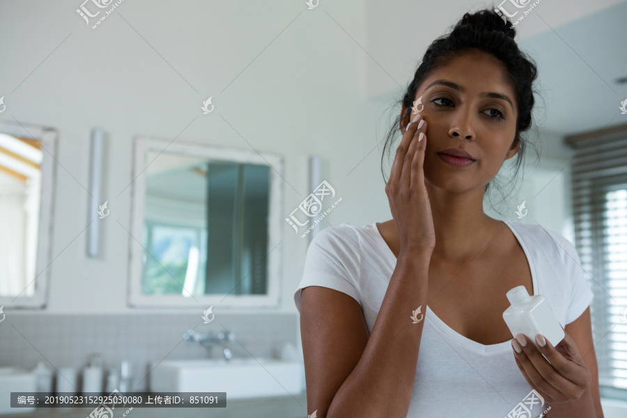 年轻女子在洗浴中涂抹乳液