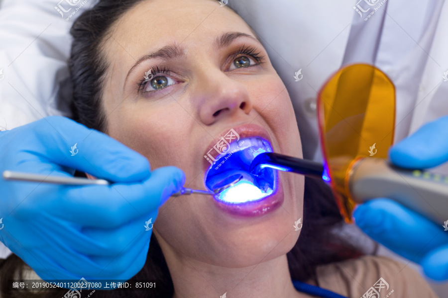 牙科医师用牙科治疗灯检查患者
