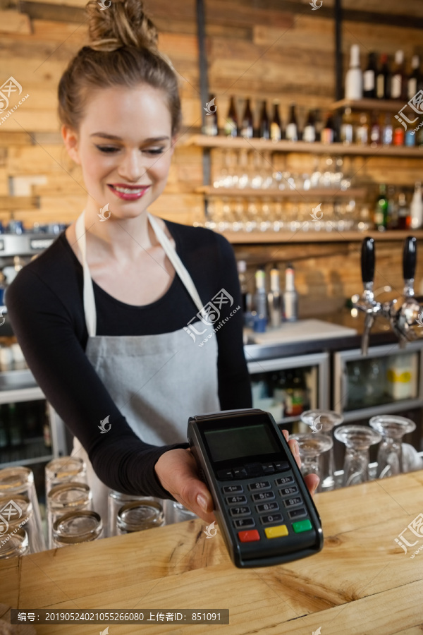 女人在咖啡店拿着信用卡读卡器
