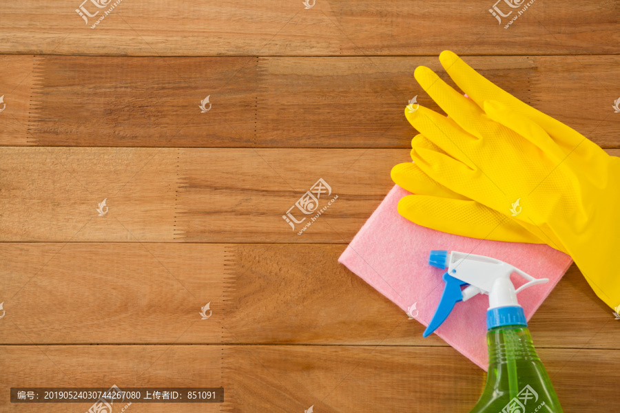 木桌上带擦拭垫和化学瓶的手套
