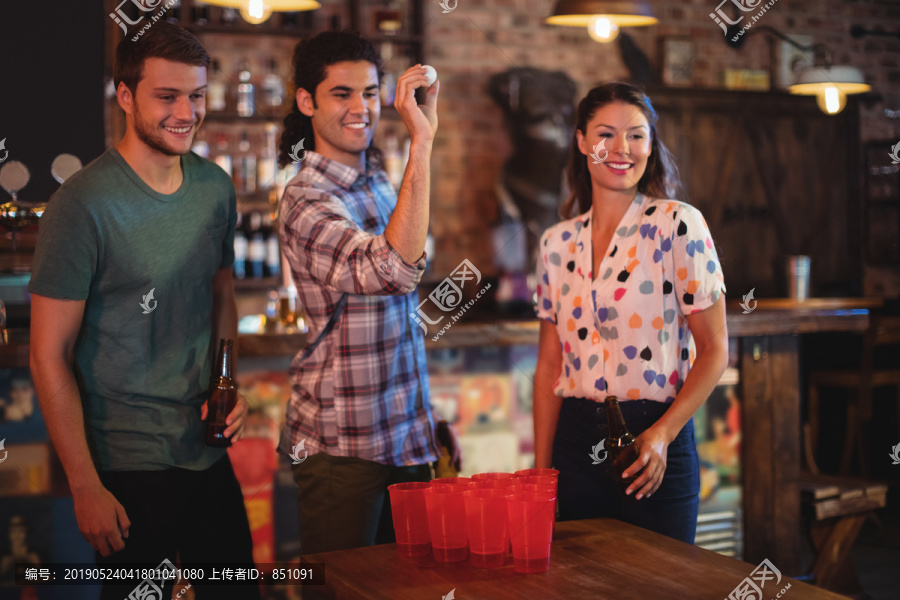 一群朋友在酒吧玩啤酒乒乓球游戏
