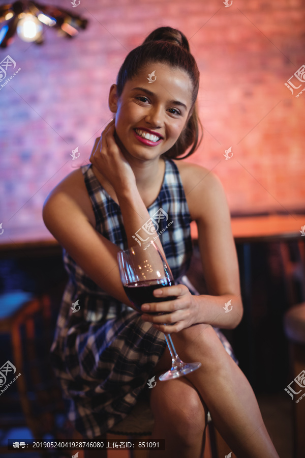 酒吧里喝红酒的年轻女子的画像