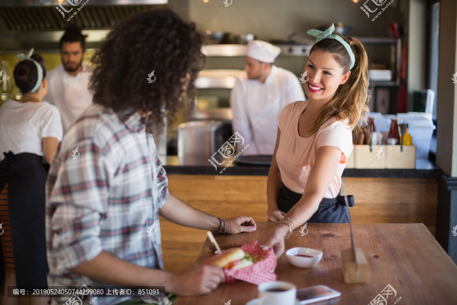 女服务员为年轻人提供汉堡
