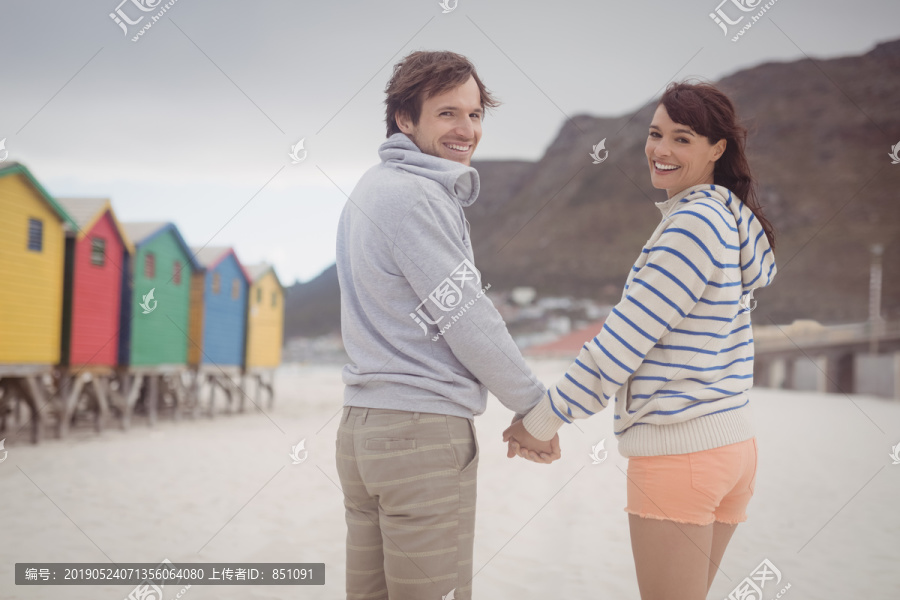 在海滩上手牵着手的夫妇