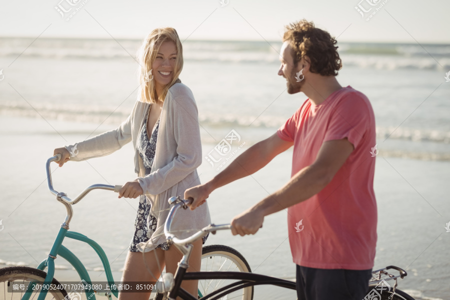 在沙滩上骑行的情侣