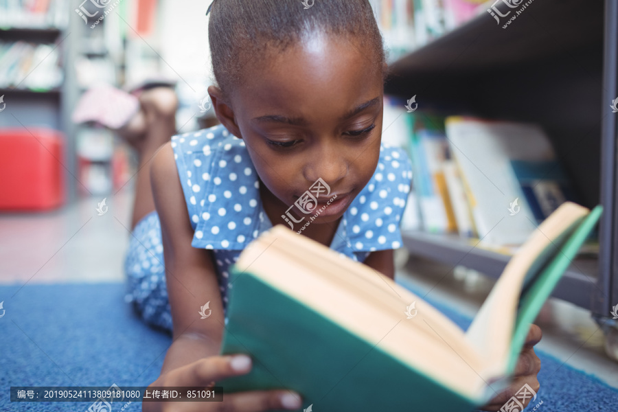 女孩躺在图书馆书架上看书