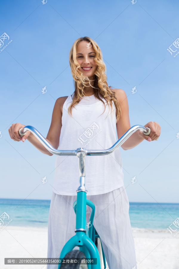 海滩上骑着自行车的年轻女人