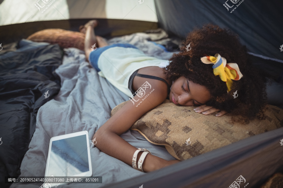 年轻女子在帐篷里用药片睡觉