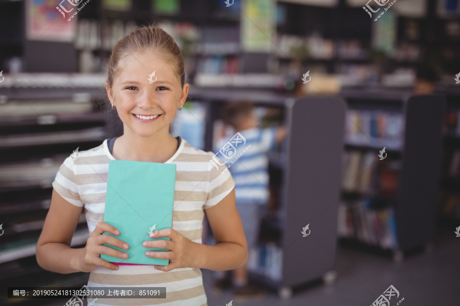 学校图书馆微笑女学生拿书画像