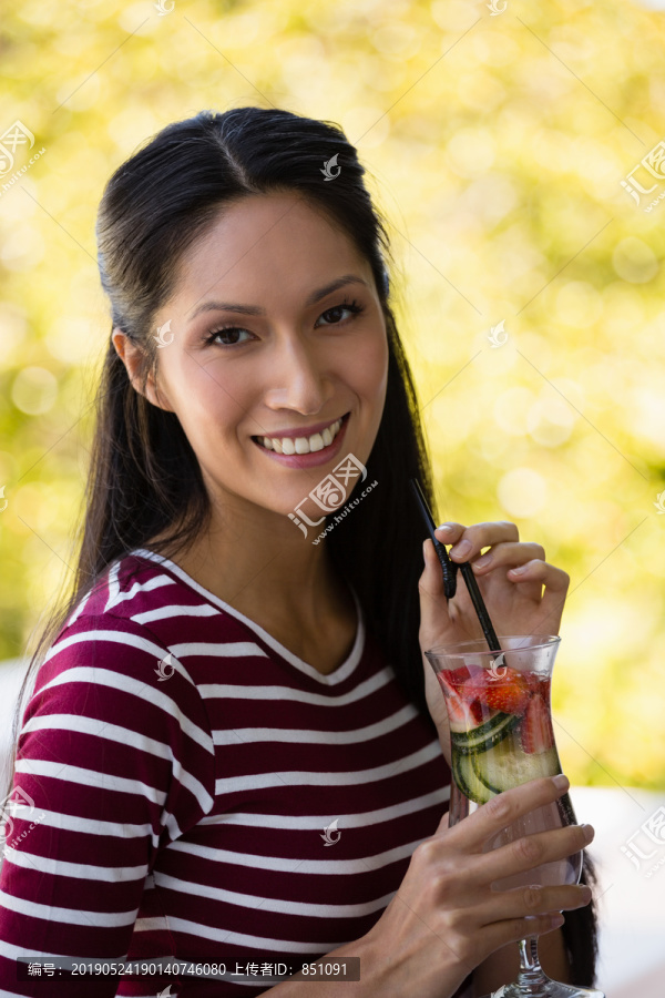 拿着鸡尾酒微笑的年轻女子