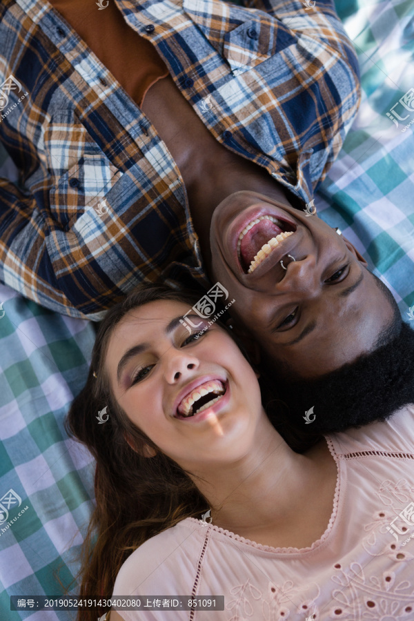 公园里躺在毯子上的夫妇