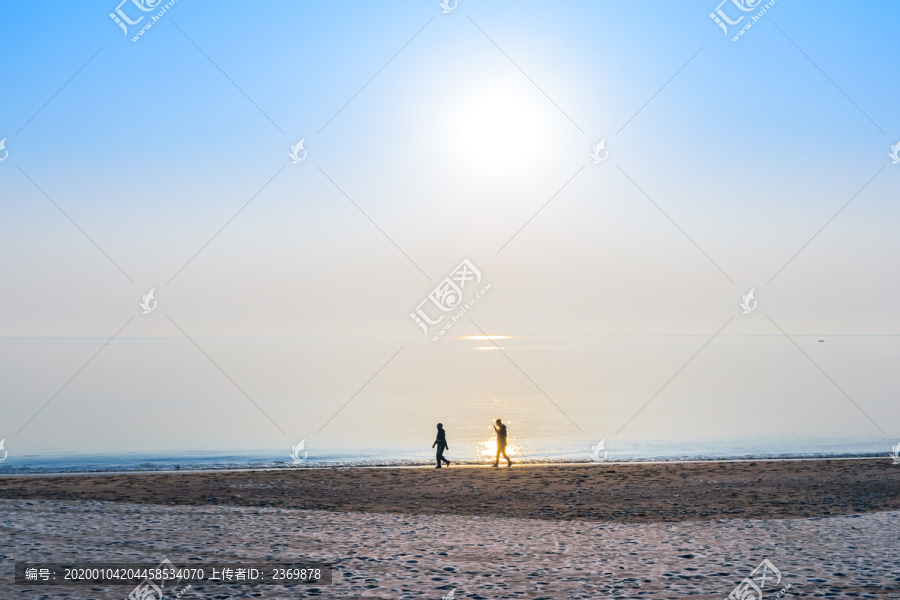 冬天清晨海边散步的两个人
