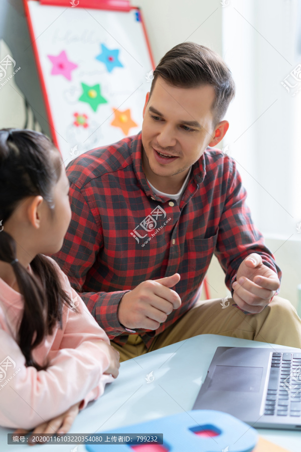 老师在课堂上辅导小学生用电脑