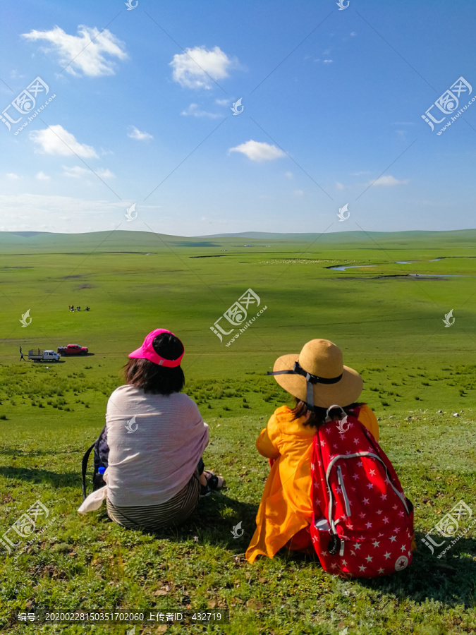 坐在草原上的女人背影