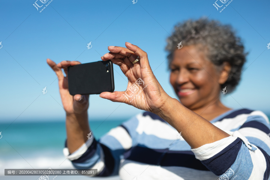 一位非洲裔美国老太太站在海滩上