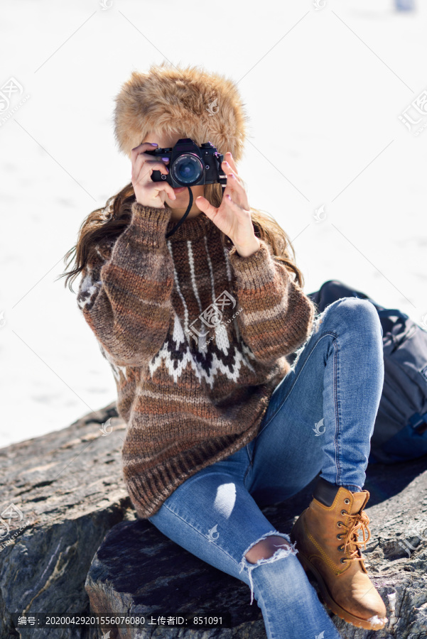 在雪山上拍照的年轻女子