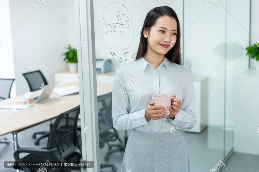 年轻商务女士在办公室喝咖啡