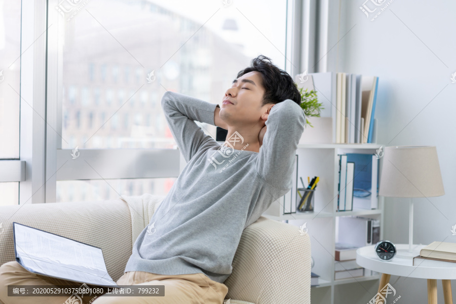 年轻男子在沙发上看文件