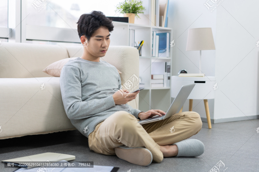 年轻男子在家使用笔记本电脑