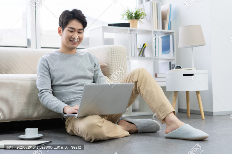年轻男子在家使用笔记本电脑
