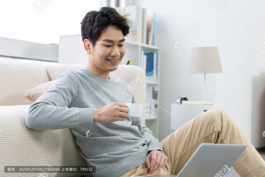 年轻男子在家使用笔记本电脑