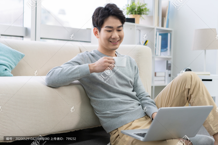 年轻男子在家使用笔记本电脑