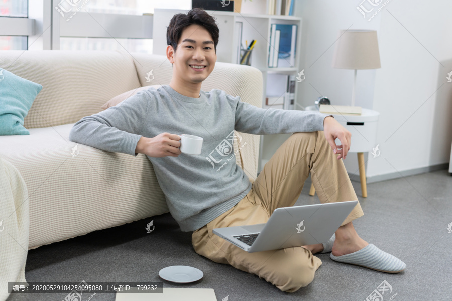 年轻男子在家使用笔记本电脑