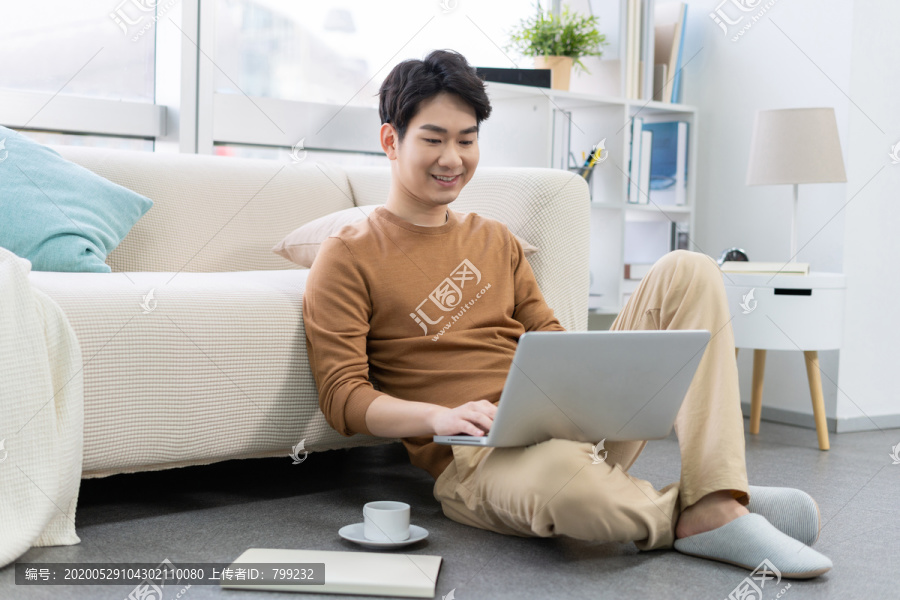 年轻男子在家使用笔记本电脑
