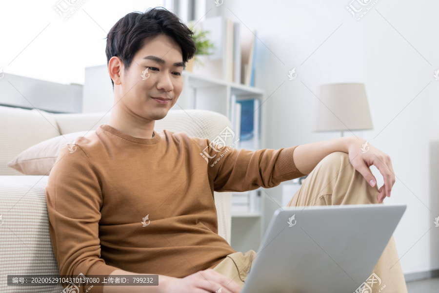 年轻男子在家使用笔记本电脑