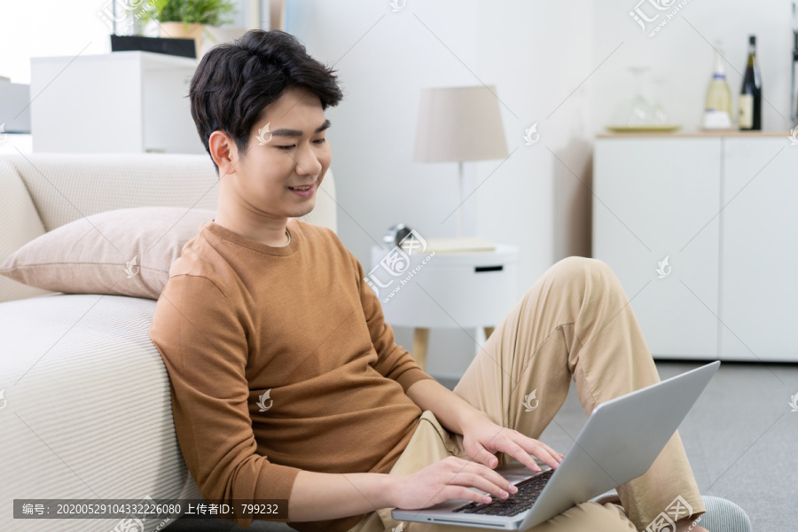 年轻男子在家使用笔记本电脑