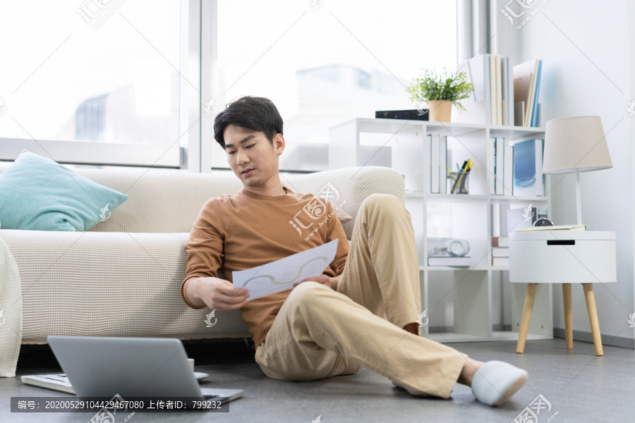 年轻男子在家使用笔记本电脑