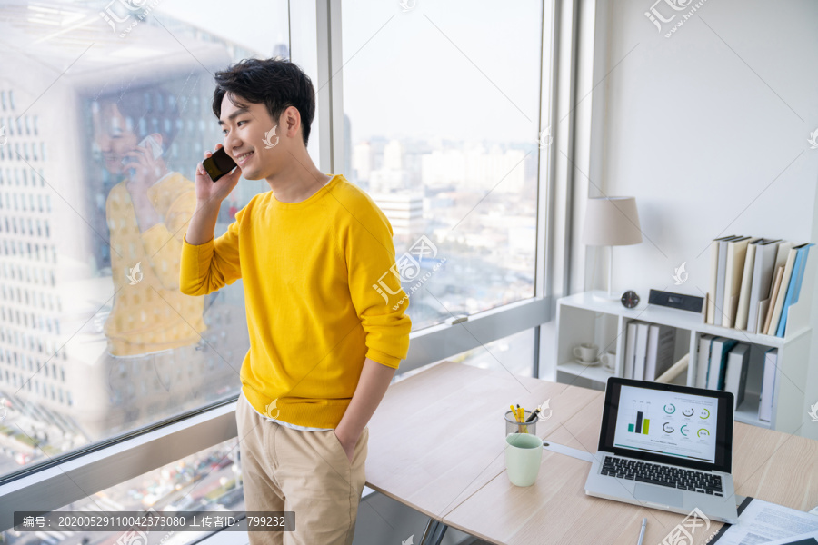 年轻男子在办公室打电话
