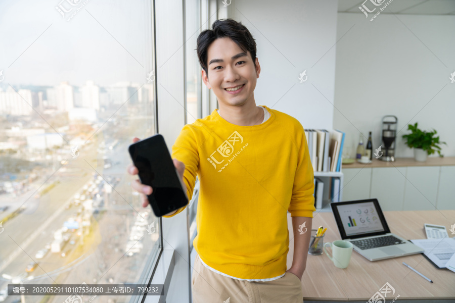 年轻男子在办公室打电话