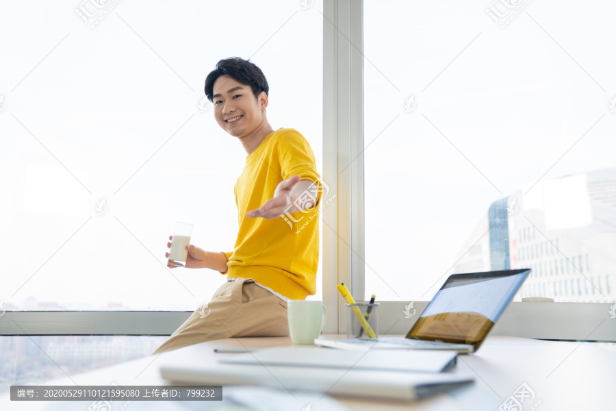 年轻男士在办公室喝牛奶
